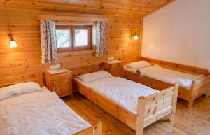 a bedroom with three beds in a log cabin at Chalet Neuhofalm Obertauern mit Sauna und Hobbyraum in Obertauern