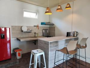eine Küche mit einer Theke und einem roten Kühlschrank in der Unterkunft Ti Pavillon in Rodrigues Island