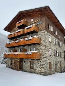 a large stone building with balconies on top of it at Pension Dangl - Glacier Rock in Solda