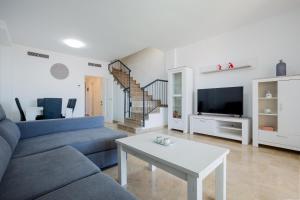 a living room with a blue couch and a table at Residencial Playa de La Arena in Puerto de Santiago