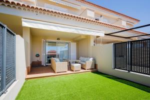 a patio with a lawn in front of a house at Residencial Playa de La Arena in Puerto de Santiago