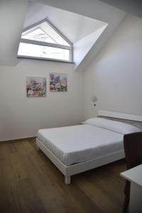 Cette chambre blanche dispose de deux lits et d'une fenêtre. dans l'établissement Hotel Villa Ruggiero, à Brusciano