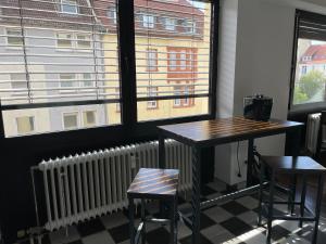 een tafel en 2 stoelen in een kamer met een raam bij Music Residence in Saarbrücken
