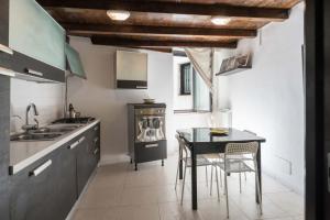 uma cozinha com uma mesa e cadeiras e um lavatório em Casa Artù em Bari