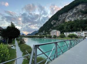 a bridge over a river next to a mountain at Center Appartement Interlaken in Interlaken