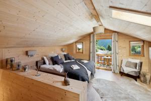 a bedroom with a bed and a couch in a room at Chalet Haute Cime by Mrs Miggins in Champéry