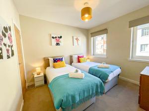 two beds in a small room with two windows at Charming Old Town 2 Bed Apt, 2mins from Royal Mile in Edinburgh