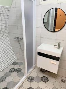 a bathroom with a sink and a shower with a mirror at Star & Moon GUEST HOUSE in Puli