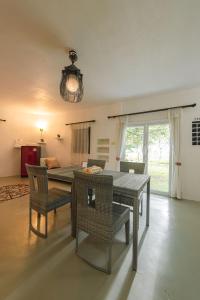 a dining table and chairs in a living room at Karaboon Wellness in Phitsanulok