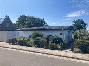 a white house with a fence in front of it at Ferienhaus Frische Brise direkt am Nordsee Deich in Spieka-Neufeld