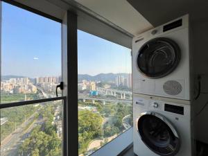 a washing machine in a room with a window at Shenzhen Fashion LOFT Apartment in Shenzhen