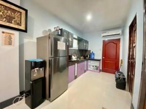 eine Küche mit einem Kühlschrank aus Edelstahl und einer roten Tür in der Unterkunft B1 - Spacious 3BR House with Netflix, Fiber Wifi, Parking, Balcony in Cagayan de Oro