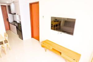 um quarto com um banco e uma televisão de ecrã plano em Lovina 3508 at Pollux Meisterstadt em Batam Center