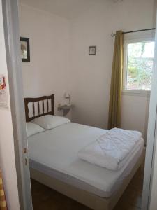 una camera da letto con un letto bianco con una finestra di Mes deux Gîtes de l'Ocre a Villars