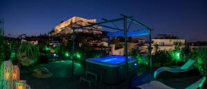 a backyard with a hot tub and a playground at night at Plaka Arch Suites in Athens