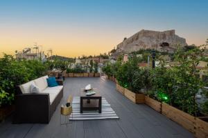 a rooftop patio with a couch and a table at Plaka Arch Suites in Athens