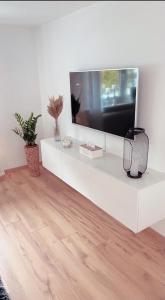 una sala de estar con TV en un estante blanco en Ferienhaus Sauerland - Traum en Winterberg