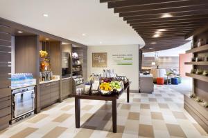 una cocina con mesa y un bol de fruta en EVEN Hotel Norwalk, an IHG Hotel en Norwalk