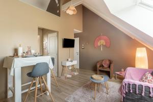 una sala de estar con una mesa y sillas en Résidence La Colombanaise, en Saint-Coulomb