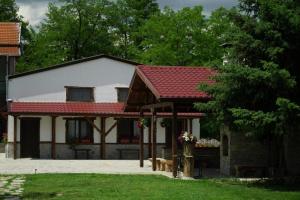 uma casa com um telhado vermelho e um edifício em Къща за гости Мелницата em Elhovo