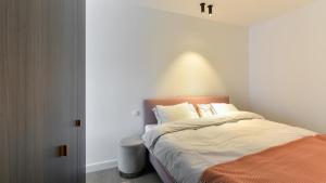 a bedroom with a bed with an orange blanket at Orfeo Knokke in Knokke-Heist