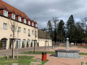 un bâtiment avec une fontaine au milieu d'une cour dans l'établissement Hotel Landhaus Wörlitzer Hof, à Oranienbaum-Wörlitz