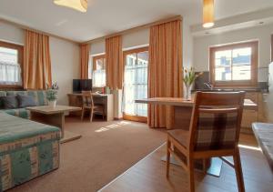 a living room with a couch and a table and chairs at Ferienhaus Birgit - inklusive Eintritt Alpentherme Bad Hofgastein in Bad Hofgastein