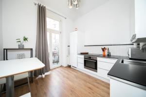 cocina con armarios blancos y encimera en WHITE 60 QM Apartment - Zentral - Balkon - Messe, en Düsseldorf