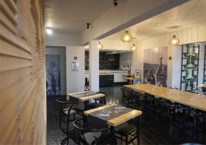 een restaurant met tafels en stoelen met wijnglazen bij Hôtel Le Glacier in Villeneuve-sur-Lot