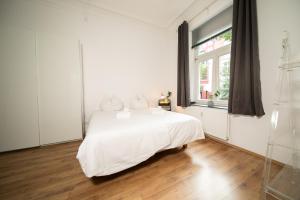 biała sypialnia z białym łóżkiem i oknem w obiekcie WHITE 60 QM Apartment - Zentral - Balkon - Messe w mieście Düsseldorf