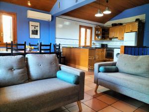 a living room with two couches and a kitchen at El Cajigar Ordesa Aínsa in Laspuña