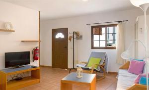 a living room with a couch and a tv at Holiday Cottage Santa Lucía 1 in Santa Lucía