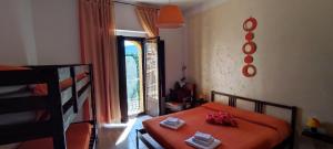 ein Schlafzimmer mit einem orangenen Bett und einem Fenster in der Unterkunft Al Cuore del Borgo in Castelmezzano