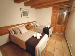 LaspuñaにあるEL CAJIGAR ORDESA 6-8 paxのベッド2台とドアが備わるホテルルームです。