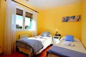 two beds in a room with yellow walls and a window at Bonito chalet con piscina cerca del mar in Can Pastilla +21 photos