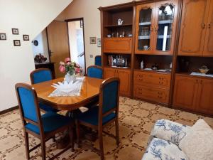 uma sala de jantar com uma mesa de madeira e cadeiras azuis em Casa Blu oltremare em SantʼAntìoco