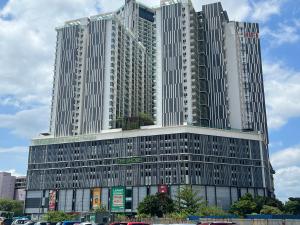 un edificio alto con coches estacionados frente a él en The Shore Melaka en Melaka