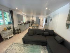 a living room with a couch and a kitchen at Gîtes de LAS RAZES in Touffailles