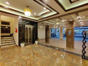 a lobby of a building with a staircase and a lobby at Hotel Divine Residency by VARSHRI in Haridwār
