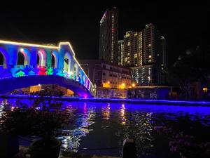 un puente sobre un cuerpo de agua por la noche en The Shore Melaka en Melaka