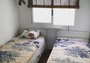 um pequeno quarto com 2 camas e uma janela em Le Montemar em Alicante