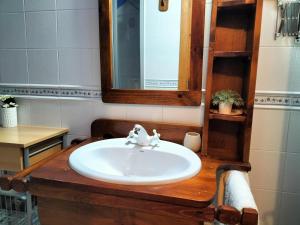 een badkamer met een wastafel en een spiegel bij EL CAJIGAR ORDESA 6-8 pax in Laspuña