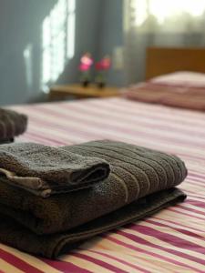 duas toalhas estão sentadas em cima de uma cama em KOLOKOTRONIS’ HOUSE em Cavala