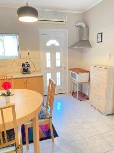 una cucina e una sala da pranzo con tavolo e lavandino di KOLOKOTRONIS’ HOUSE a Kavala