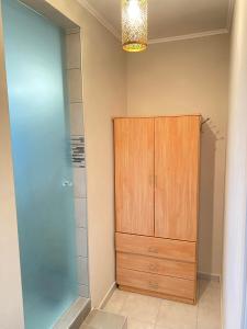 baño con ducha y armario de madera. en KOLOKOTRONIS’ HOUSE en Kavala