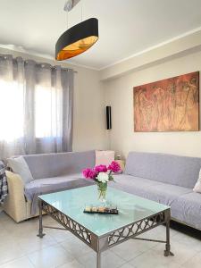 KOLOKOTRONIS’ HOUSE في كافالا: غرفة معيشة مع أريكة وطاولة
