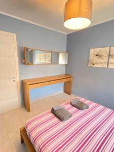 ein Schlafzimmer mit einem Bett mit einer gestreiften Decke in der Unterkunft KOLOKOTRONIS’ HOUSE in Kavala