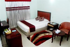 een hotelkamer met een bed en een stoel bij Meridian Hotel in Chittagong