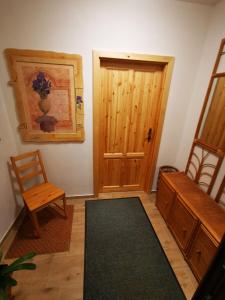 a room with a wooden door and a chair at Apartmán na Náměstí 55 in Drnholec