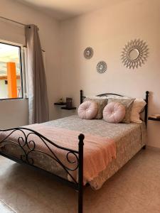 a bedroom with a bed with pink pillows and a mirror at CASA LITO in Haría